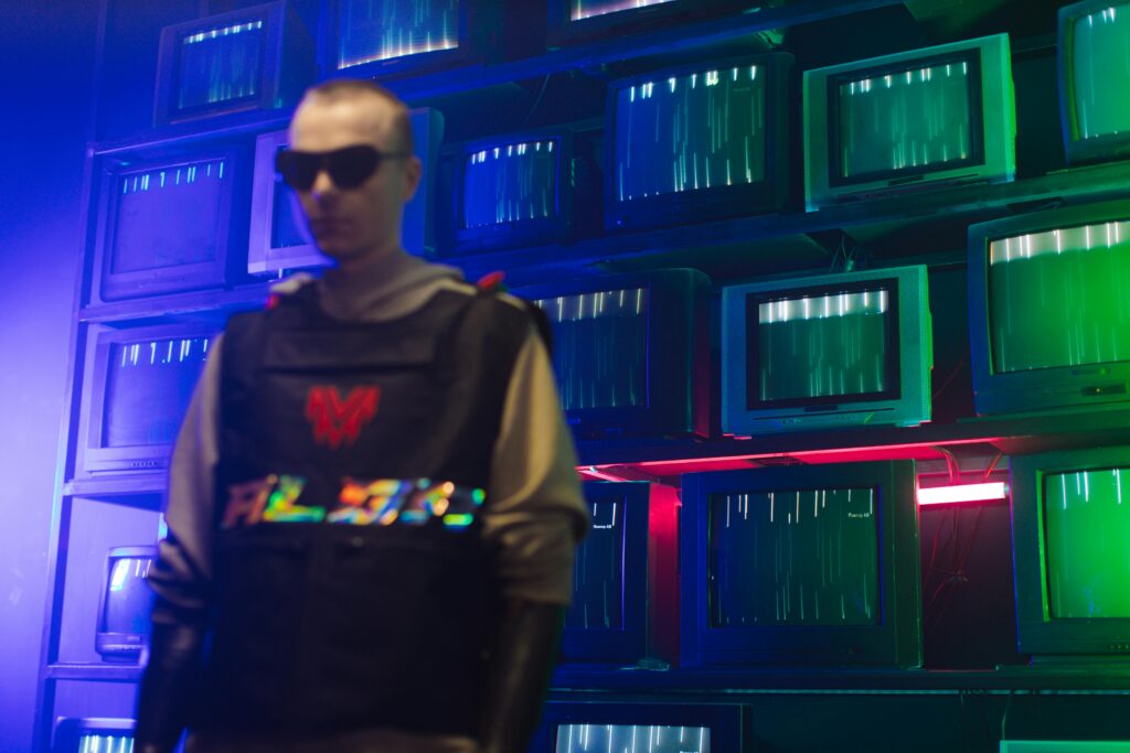 Futuristic cyberpunk setting with a man in sunglasses and vintage TVs displaying static lights.